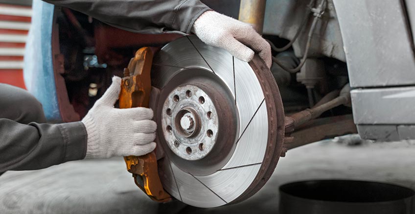 Brake repair technician examining brake pads in Burnaby